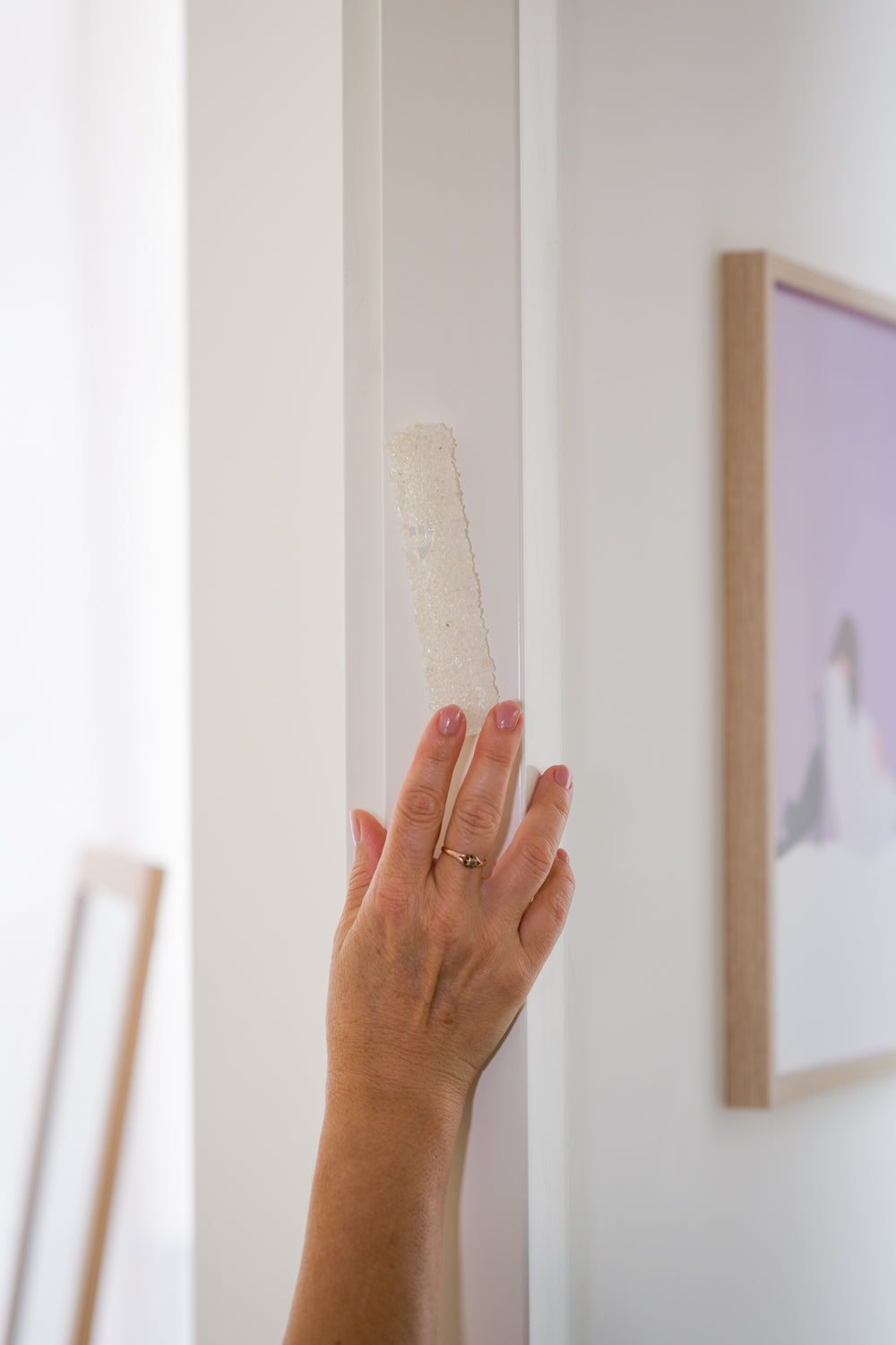 Handmade crystal white mezuzah case on a doorpost, being touched and kissed by Jewish tradition.