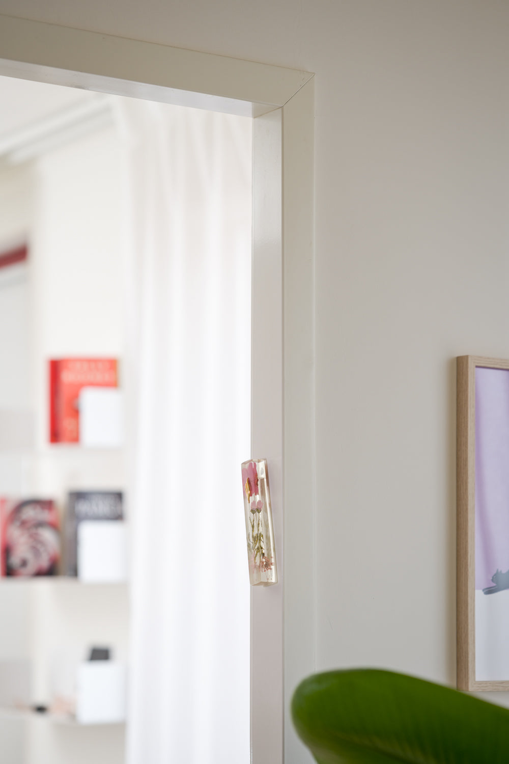 Handmade blue floral mezuzah case on a doorpost, placed by the Jewish tradition.
