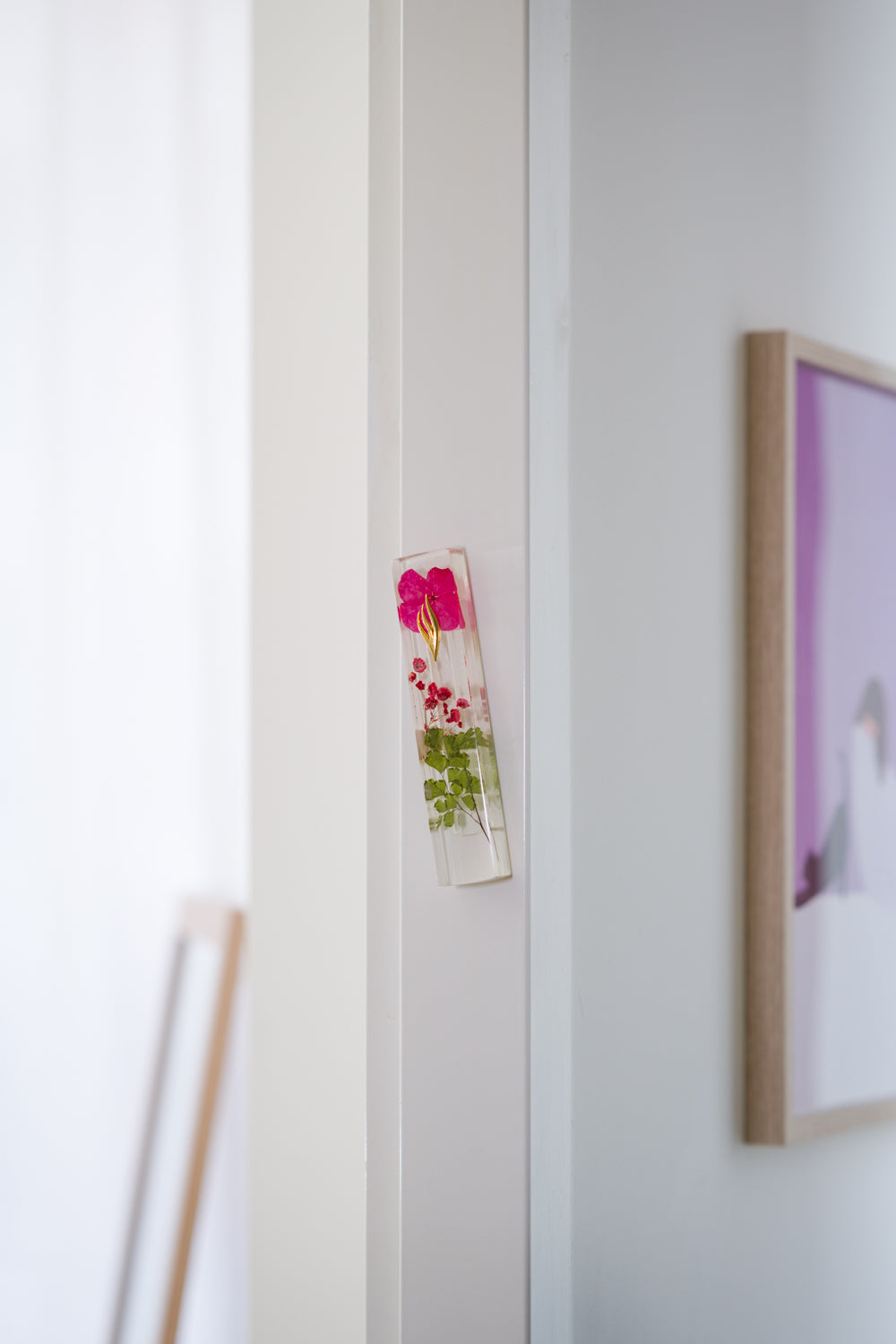 Handmade red floral mezuzah case on a doorpost, placed by the Jewish tradition.
