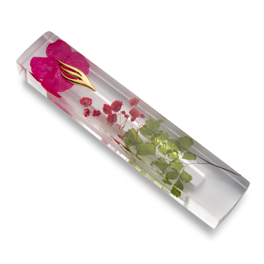 Handmade mezuzah crafted from clear resin and red preserved flowers, featuring a golden Shin symbol on the front.