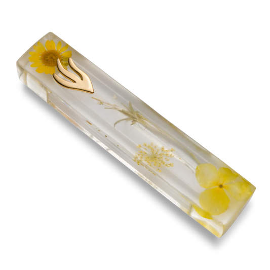 Handmade mezuzah crafted from clear resin and yellow preserved flowers, featuring a golden Shin symbol on the front.
