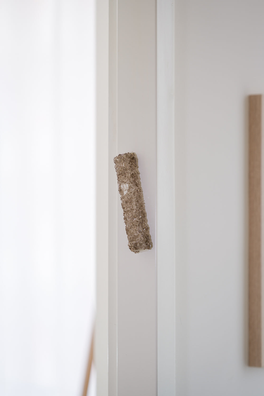 Handmade crystal brown mezuzah case on a doorpost, placed by Jewish tradition.
