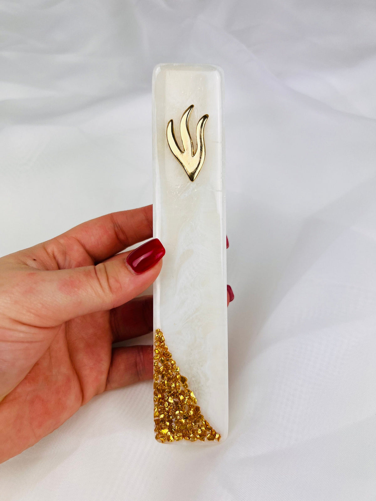 Handmade white marbled resin mezuzah case on a doorpost